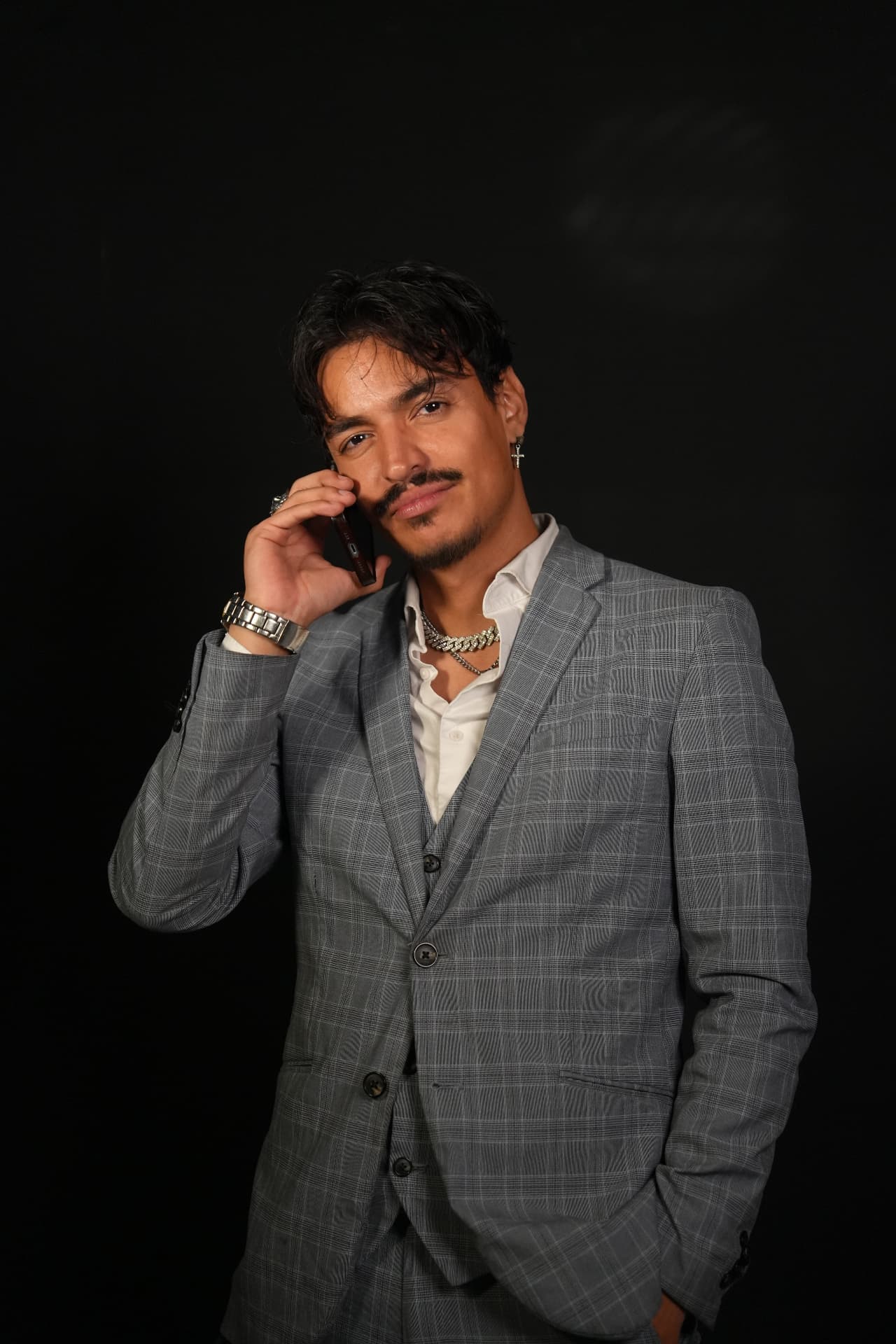 Portrait of Nico Rozu in a gray plaid suit on a call